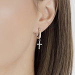 Close-up of an ear wearing a 925 sterling silver hoop earring with a cross pendant - Olivia Star Jewelry