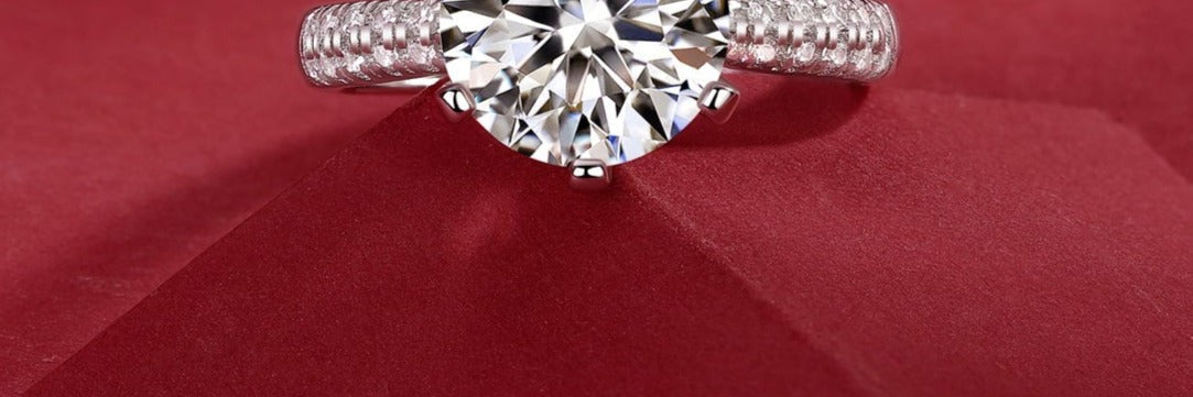 Moissanite solitaire ring in sterling silver on red velvet