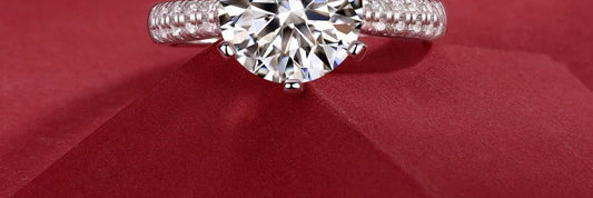 Moissanite solitaire ring in sterling silver on red velvet